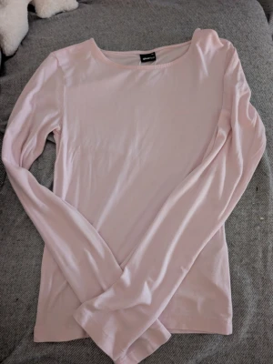 Ljusrosa långärmad topp Gina Tricot xs - En enkel och stilren ljusrosa långärmad topp från Gina Tricot i mjukt material. Modellen har rund halsringning och en rak passform som funkar till många olika looks. Perfekt basplagg att ha i garderoben.