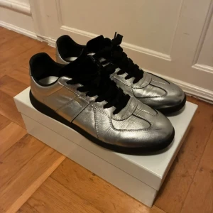 Helt nya Maison Margiela Gats - Helt nya silvriga Gats, skriv för mer mer info.                     Skokartong ingår.                                                          Innersula 29 cm.                                                              0bs lnte 0rglnaI
