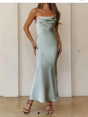 Bal klänning Ljusgrön långklänning i satin - Säljer nu min bal klänning i ljusgrön färg en långklänning från Hello Molly i glansigt satinmaterial. Klänningen har tunna axelband som korsas i ryggen har endast använts en gång och är i storlek xs-s kan skicka fler bilder om de önskas.Ny pris 900kr