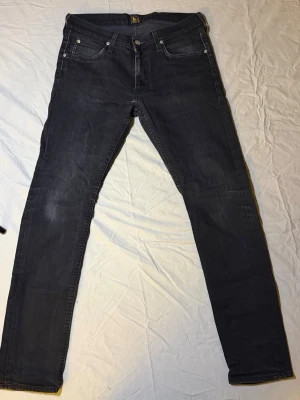 Lee Luke jeans mörkgrå – Slim fit – 32/32 – Mycket bra skick - Säljer ett par Lee Luke jeans i mörkgrå färg, slim fit, storlek 32/32, i mycket bra skick. Väldigt stilren färg som funkar perfekt till både svarta, vita och neutrala outfits.  Luke-modellen ger en modern slim siluett som sitter snyggt utan att bli för tight. Lätta att styla för både streetwear och clean vardagslook.  Mått: Midja: 42 cm Längd: 106 cm  • Märke: Lee • Modell: Luke • Passform: Slim fit • Skick: Mycket bra  Lee 6