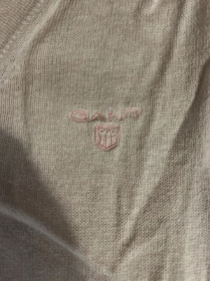 Rosa v-ringad tröja från Gant XL - Säljer en rosa v-ringad tröja från Gant i storlek XL. Tröjan har diskret broderad logga på bröstet och är tillverkad i mjukt material. Klassisk passform och ribbade muddar vid ärmslut och nederkant. Perfekt för lager på lager under hösten.