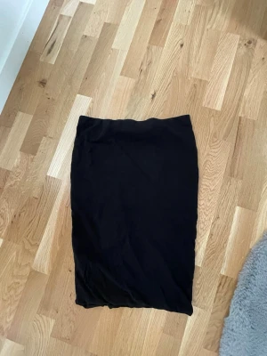 Svart basic kjol - En enkel svart kjol i rak modell från H&M, storlek M