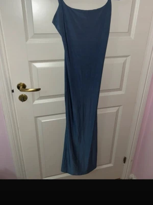 Blå långklänning från SHEIN - Säljer en blå långklänning från SHEIN i storlek XS. Klänningen har smala axelband och en enkel, rak siluett som ger en clean och stilren look. Materialet är mjukt och följsamt, perfekt för sommarens alla tillfällen.