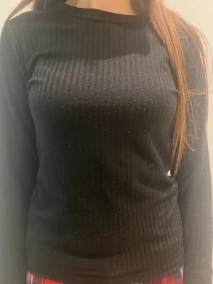 Svart ribbad långärmad topp True North - Säljer en svart långärmad topp från True North med ribbad struktur. Kan användas som underställ till vintern. Perfekt till chill eller lager på lager under kalla dagar. Är lite kort vid armarna dock 