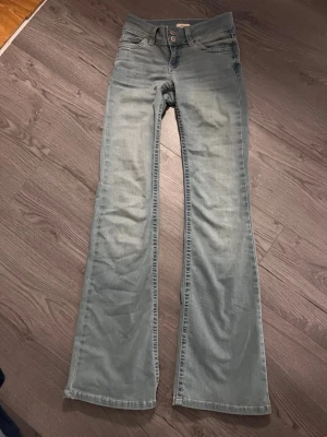 Bootcut jeans ljusblå från Nelly - Säljer ett par ljusblåa nelly jeans med rosa design på fickorna. Bara testad och var för små på mig💕
