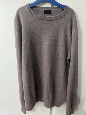 Beige merinoulltröja från Swedish Fashion - Mjuk och stilren beige tröja från Swedish Fashion i storlek XS. Tillverkad i 90% merinoull och 10% kashmir för extra lyxig känsla. Klassisk rund halsringning och långa ärmar, perfekt för lager på lager under kyliga dagar.
