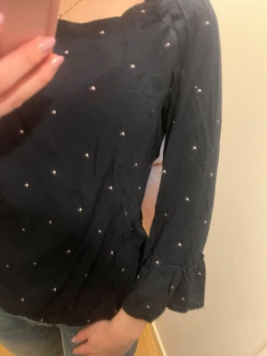 Mörkblå prickig tröja med trekvartsärmar  - Prickig mörkblå tröja med lite utvändigt längst ner på ärmarna och lite figursydd.