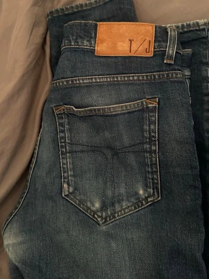Tiger of Sweden jeans  - Säljer ett par blå Tiger of Sweden jeans. Dem är i bra skick men har en defekt i form av ett litet hål