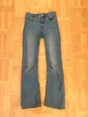 Blå bootcut jeans från LAB Industries💖 - Säljer ett par klassiska blå jeans från LAB Industries med bootcut passform. Jeansen har fem fickor, slitning på höger ben och en snygg tvättad look. Tillverkade i bomull med en avslappnad vibe och etikett bak i midjan.