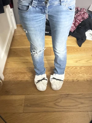 Ljusblå pepe jeans Venus W10 - Säljer ett par ljusblå  jeans från pepe jeans i storlek W10. De har låg midja, slitningar och hål på ena benet för en trendig look. Klassisk femficksmodell med snygga detaljer på bakfickan. Perfekta till sneakers eller boots.jätte trendiga och sitter jätte fint, super bra skick. Postar samma dag skriv ifall du har en fråga🥰😇🫰🏽