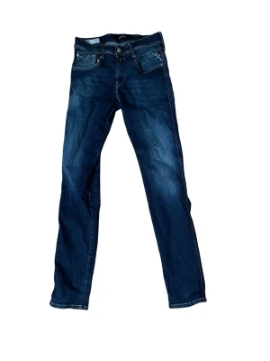 Replay mörkblå jeansbyxor straight - Säljer ett par mörkblå jeans från Replay med klassisk femficksdesign och raka ben. Jeansen har snygga kontrastsömmar och Replay-logga på myntfickan. Materialet är slitstarkt jeans i bomull med en skön passform.