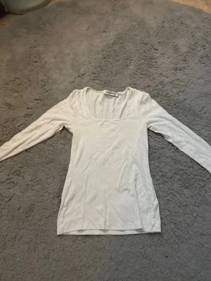 Vit ribbad topp Carin Wester - Säljer en tunn, ribbad långärmad topp från Carin Wester i vitt. Toppen har en fyrkantig ringning och är gjord i ett lätt material som känns luftigt och skönt.