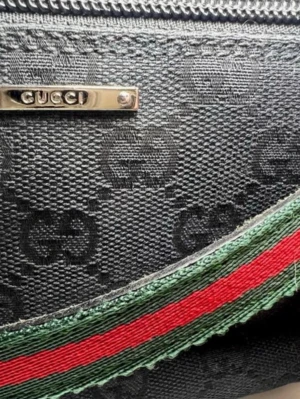Vintage Gucci väska  - Äkta vintage och sällsynt boat axelväska från Gucci i tyg med klassiskt GG-mönster över hela väskan. Det som gör den sällsynt är att axelremmen är i grönt och rött (de flesta som finns till salu är bara svarta) den ger en sportig känsla o är lite slitet på undersidan men syns knappt. Silver detaljerna är fortfarande lika shiny som när jag köpte den ✨Väskan har dragkedja upptill och metallplatta med Gucci-logga framtill. Perfekt storlek för det viktigaste.Kommer med äkthetsbevis från The Vintage 