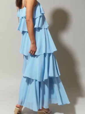 Ljusblå volangklänning med axelband - Ärmlös långklänning med volanglager. Klänningen är perfekt för festen, blå och fodrad. Den har reglerbara axelband och dragkedja bak.  Använd 2 gånger  Ordinarie pris: 799kr