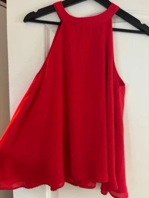 Halterneck topp - Säljer röd blus med hög hals och knappar i nacken. Fint skick❤️❤️