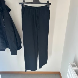 Linnebyxor - Svarta linnebyxor. Byxorna har raka ben och sidofickor. Använda få gånger. H&M