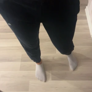 Svarta mjukisbyxor från Puma - Svarta mjukisbyxor från Puma i storlek s (ganska små i storlek). vit broderad logga på benet och snören i midjan. Byxorna har en avslappnad passform och är tillverkade i mjukt bomullsmaterial, perfekta för chill dagar eller träning.🥰