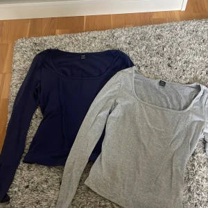 Två långärmade toppar från Shein - Säljer två stilrena långärmade toppar från Shein. Ena toppen är marinblå och den andra är ljusgrå, båda med snygg fyrkantig urringning. Materialet är mjukt och stretchigt, troligen bomull eller polyester. Vill man bara ha ena går det bra också!