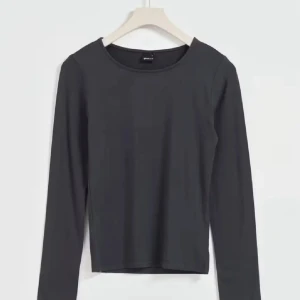Mörkgrå långärmad topp - En stilren mörkgrå långärmad topp från Gina tricot med rund halsringning. Toppen har en enkel och clean design som är lätt att matcha med olika outfits. Perfekt basplagg i garderoben.