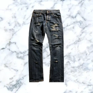 Nudie jeans - Tjenare! Säljer ett par one of a kind Nudie jeans för 499kr (pris kan diskuteras)🔥jeansen har väll gjorda slitningar och ett hål vid skrevet som är ordentligt ihopsyt och inte syns (finns bild)🪡jeansen är i storlek W29 L32 men skulle säga att dem passar upp till ungefär W31👖dem är av modellen Grim Tim vilket är en rakare och enligt mig en sjukt snygg model💯Hör gärna av er vid minsta fråga eller i behov av mer bilder, Mvh 2000s Wardrobe👋