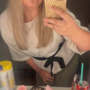 Vit kofta med svart knytband - Säljer en vit kofta med trekvartsärm och ett svart knytband i midjan som ger en snygg siluett. Koftan har en mjuk och lite loose passform, perfekt att styla med jeans eller kjol. Enkel och stilren design som passar dig som gillar minimalistiskt.