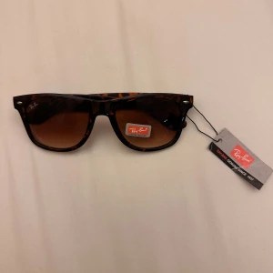 Rayban boyfriend - Snygga solglas från Ray-Ban med brunmelerad båge och bruna tonade glas. Klassisk modell med cool retrostil och diskret logga på linsen. Perfekta för att lyfta din look i sommar.
