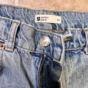 Blå ripped jeans från Gina Tricot - Snygga ljusblå jeans från Gina Tricot med raka ben och slitna detaljer vid knäna. Modellen har klassisk femficksdesign, dragkedja och knapp framtill. Premium denim med cool vintagekänsla, perfekt för dig som gillar streetstyle.