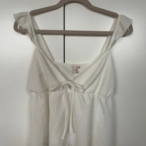 Vit linnetopp med knyt från Nelly - Supersöt vit linnetopp från Nelly med v-ringning och knyt framtill. Strl M. Oanvänd och fint skick. Nytvättad och steamad. 🤍