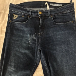 Mörkblå bootcut jeans från lois - Snygga lågmidjade utsvängda byxor med smått slitningar