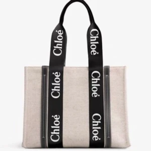Chloé shoppingväska med logoband - Snygg shoppingväska från Chloé i beige canvas med breda handtag prydda med Chloé-logga. Finns med svarta eller vita band och detaljer i svart eller brunt skinn. Rektangulär form, perfekt för att bära allt du behöver. Stilren och trendig design som sticker ut.