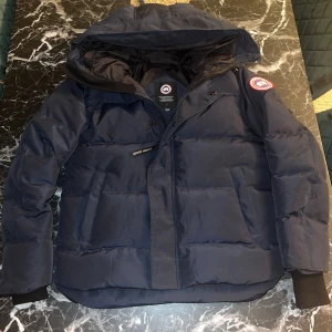 Canada goose mcmillian parka - Säljer min Canada Goose Macmillan i färgen Navy Blue. Jackan är i nästan nyskick, endast använd i en vecka, så den är i perfekt skick utan några skador, fläckar eller tecken på slitage.  Storlek: M Färg: Navy Blue Originalpris: ca 12 000kr Mitt pris: 3999  Jackan är 100% äkta, med alla originaldetaljer och etiketter kvar. Mycket varm, bekväm och snygg passform – perfekt för vintern.  Kan skickas spårbart eller mötas upp om du bor i närheten.