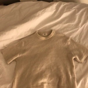 Beige stickad tröja Gina Tricot - Mysig beige stickad tröja från Gina Tricot i ullblandning. Tröjan har korta ärmar och rund hals.  Använd ett fåtal gånger och i ett bra skick🤍