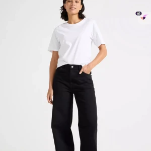 Svarta wide jeans med hög midja - Snygga svarta jeans med mid midja och breda ben. Klassisk femficksmodell med knapp och dragkedja framtill. Jeansen har raka, vida ben. Aldrig använda och prislapp kvar 