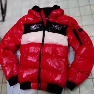 Calvin Klein - Extreme Slim Fit Pufferjacka - Röd/Blå/Vit - Pufferjacka från Calvin Klein köpt i New York för 200$ förra vintern men knappt blivit använd. Extreme Slim Fit-modell men ändå väldigt varm. Normal i storleken och allt dun är där det ska vara.