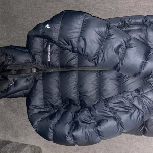 Mörkblå dunjacka Peak Performance - Säljer en mörkblå dunjacka från Peak Performance med huva och dragkedja. Nypris för dessa jackor är ca 3800, det var så mycket jag köpte den för från PeakPerformance. Mitt pris är 1599kr. Den är använd i ca 4 veckor men har tagit hand om den så bra som möjligt, finns ingen slitage alls. Den är i storlek S men passar mig som även har storlek M. Pris kan även diskuteras!
