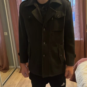 Svart rock med fickor och knappar - Säljer en svart rock med knappar o fickor riktigt varm till höst o vintern och väldigt stilren, använd endast 2 gånger, inte riktigt min stil, passar både M och L