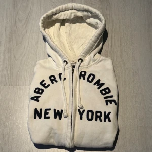 Abercrombie & Fitch Hoodie - Säljer en riktigt fet Abercrombie & Fitch Hoodie med ett unikt tryck, tröjan har en defekt vilket är en liten fläck som knappt syns vid ärmen som syns på sista bilden men det påverkar inte användningen och går även att få bort | Storlek: S | Skick: 7/10 | Pris: 499