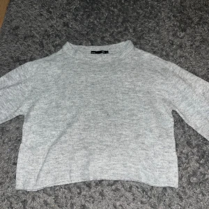 Ljusgrå stickad tröja från 157 - Mysig ljusgrå stickad tröja från 157 i storlek S. Tröjan har en enkel och clean design med rund hals och långa ärmar. Perfekt för att hålla dig varm under kyliga dagar nu i höst och vinter. Passformen är normal och materialet känns mjukt mot huden. Använd fåtal gånger.