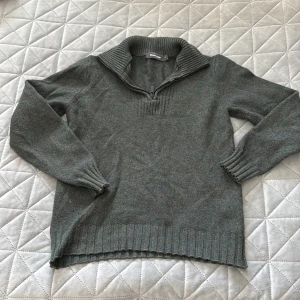 Grön stickad half zip-tröja Dressmann - Mysig grönmelerad stickad tröja från Dressmann i storlek S. Tröjan har en ribbad krage med half zip-dragkedja och långa ärmar med ribbade muddar. Perfekt för kyliga dagar och har en klassisk, chill vibe.