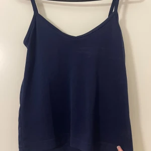 Mörkblå linnetopp från Hennes - Enkel och stilren mörkblå linnetopp från Hennes Collection. Toppen har smala axelband och v-ringning, perfekt att matcha med jeans eller kjol. Mjuk och skön känsla, passar till många olika looks.