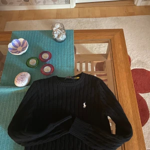 Svart stickad tröja från Polo Ralph Lauren - Snygg svart stickad tröja från Polo Ralph Lauren, köpte den begagnad från Vinted inte så säker på att den är äkta, säljer den nu då det står på tröjan att storleken är M men den känns definitivt mer som S då den är ganska liten. Så köp inte ifall du normalt sätt har M på tröjor. 