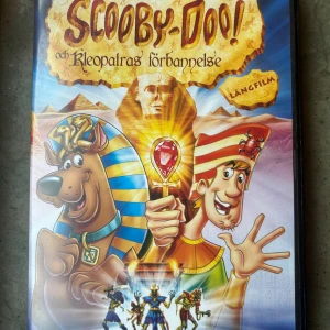 Scooby doo och kleopatras förbannelse DVD - Följ med Scooby-Doo och gänget på ett spännande äventyr i Egypten där de löser mysteriet med Kleopatras gravkammare. Denna långfilm bjuder på spänning och humor för hela familjen.  Finns på språk: Svenska, Finska, Norska, Engelska  OBS!! skivorna är begagnade så det kan förekomma repor/hairlines på skivorna, men då jag kollar igenom alla filmer jag säljer garanterar jag att alla funkar felfritt om inget annat står! 