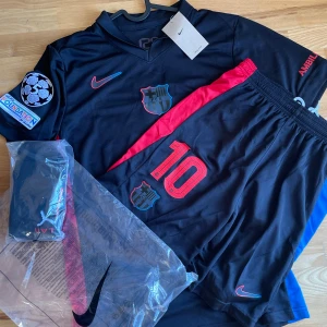 FC Barcelona Lamine Yamal Nike set  - Säljer en svart FC Barcelona set, med Lamine Yamal och nummer 10 på ryggen. Artikeln är original och är aldrig använda och helt ny med prislapp. 