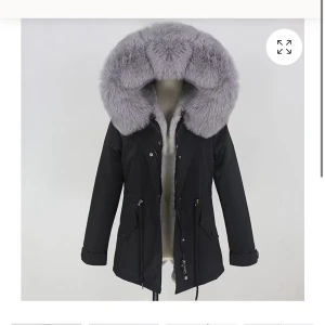 Svart parkajacka med grå pälsdetaljer - Denna Scarlett Jacket från Femenina of Sweden köptes förra året. Det är en svart vinterjacka med en stor, grå pälskrage. Storlek S   	•	Pälsen kan användas som en separat väst. 	•	Jackan är vändbar och kan bäras åt båda hållen. 	•	Varm och stilren med mjukt innerfoder. 	•	Figursydd passform med dragsko i midjan.  En snygg och praktisk jacka för kallt väder! Jackan är köpt för 3699!