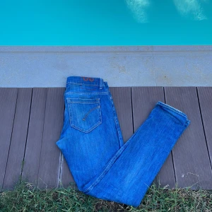  dondup jeans - Snygga blå jeans från Dondup, modell George Skinny Fit. Jeansen har klassisk femficksdesign, smal passform och är tillverkade i mjukt denimtyg. Perfekt för dig som gillar en modern och slimmad look. Made in Italy.