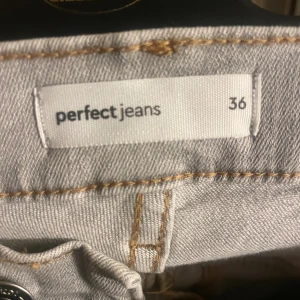 Grå jeans från Perfect Jeans, strl 36 - Snygga grå jeans från Perfect Jeans i storlek 36. Klassisk femficksmodell med raka ben och normal passform. Jeansen har ljusgrå ton, synliga sömmar och är tillverkade i mjukt denim-material. Perfekt för dig som gillar stilrena och enkla jeans.