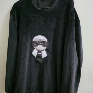 Svart sammetsset med FF - Snyggt svart sammetsset från FF med coolt broderat motiv framtill på både tröja och byxa. Tröjan har rund halsringning och byxorna har dragsko i midjan samt dragkedjor vid fickorna. Perfekt för dig som gillar statement-plagg och mjuka material.