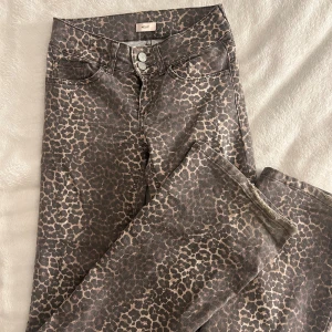 Leopardmönstrade bootcut jeans  - Säljer ett par jättefina leopard jeans från Nelly med måtten: midjemått: 68 cm och längd: 104 cm. Har tecken på användning längst ner med lite slitningar.😇