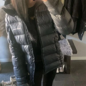 Svart dunjacka från Peak Performance - Säljer en svart dunjacka från Peak Performance med huva och dragkedja. Dragkedjan är utbytt men finns inga tecken på det. Jackan är en lite längre modell i storlek XS men skulle säga att den även passar S. Perfekt för kalla dagar och riktigt skön att bära. Klassisk logga på bröstet och ärmen. Jackan är i nyskick å i princip oanvänd, därmed inga defekter alls. Fråga gärna om fler bilder om det behövs❣️