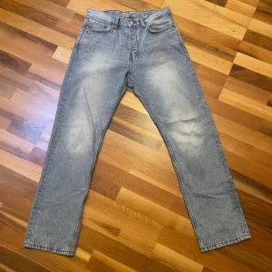 Weekday jeans - Ljusblå weekday jeans med klassisk femficksdesign och raka ben. Jeansen har en snygg tvätt med subtila slitningar och knappgylf. Perfekt för dig som gillar tidlös stil och vill ha ett par jeans som funkar till allt. Relaxed passformz. Jeansen är använda ett fåtal gånger, och är felfria. Skriv för fler bilder, kan gå ner i pris vid snabb affär. (W28, L32)